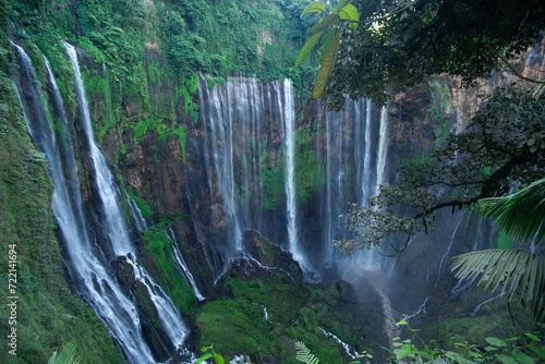 Scenic view of lush waterfalls amidst vibrant green vegetation