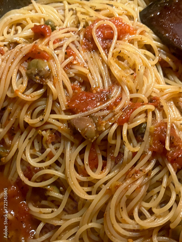 Closeup of fresh spaghetti putanesca with selective focus on foreground photo