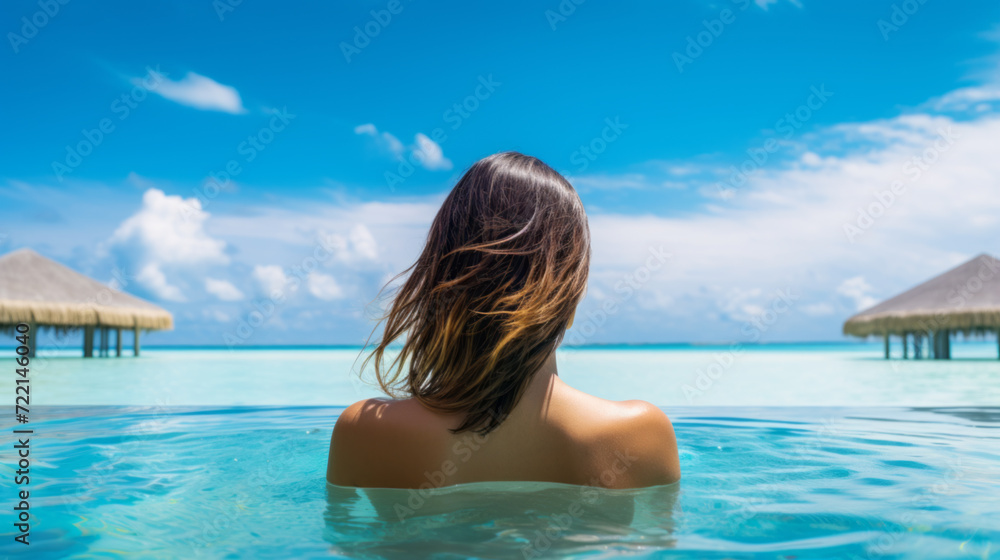 Woman Relaxing in Infinity Pool Overlooking Ocean Woman Relaxing in Infinity Pool Overlooking Ocean