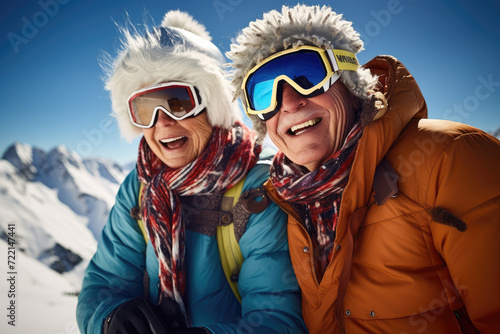 Happy senior couple in winterwear standing on top of a snowy mountain © Kitta
