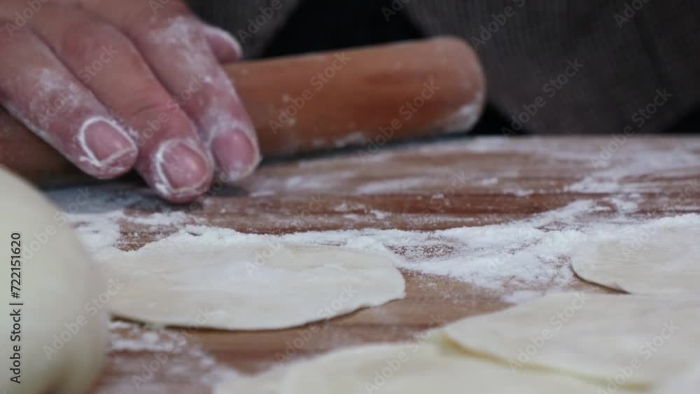 Making traditional Chinese dumplings,Roll out dumpling wrappers on wooden board Making traditional Chinese dumplings,Roll out dumpling wrappers on wooden board