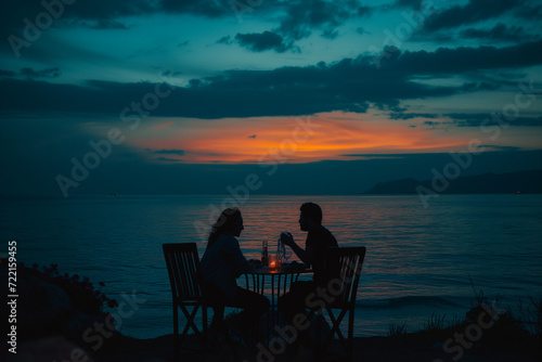 couple sitting on a beach at sunset
