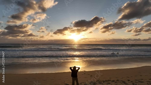 Chica viendo la puesta de sol en la playa photo