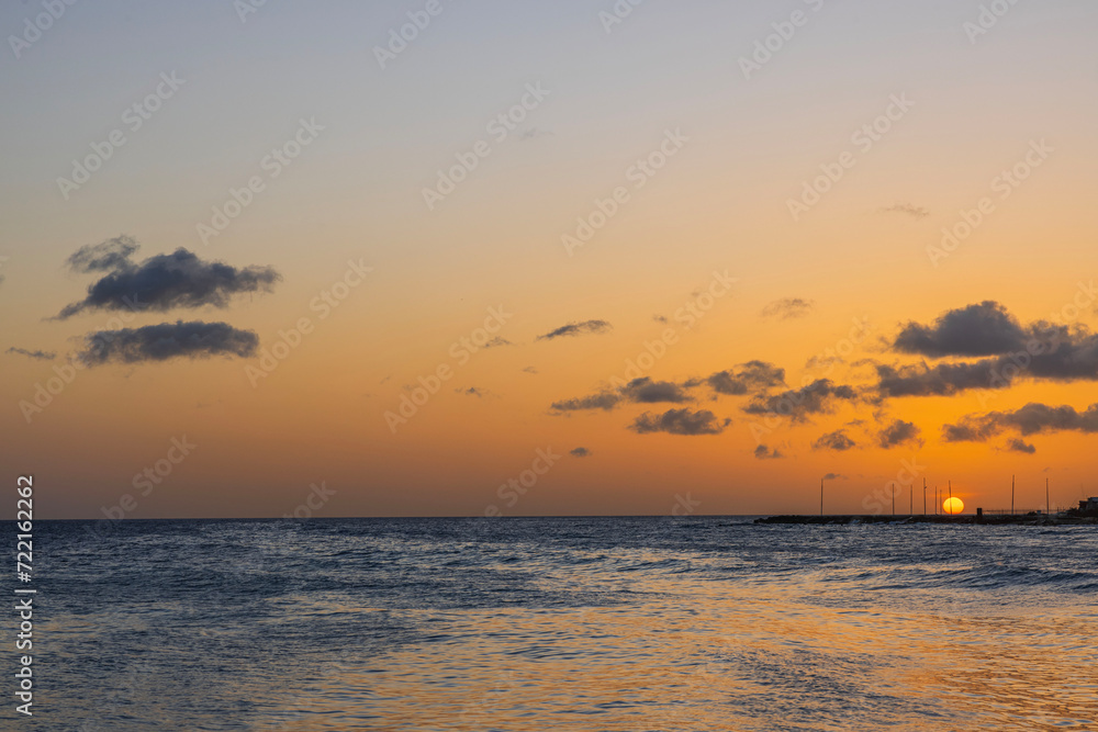 Captivating view of a orange sunset on island Curacao's horizon in the Caribbean Sea.