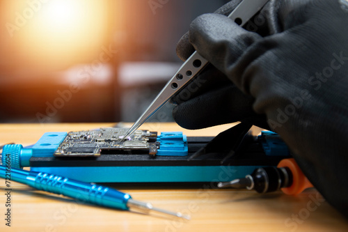 side view Technician is repairing Smartphone motherboard, circuit repair