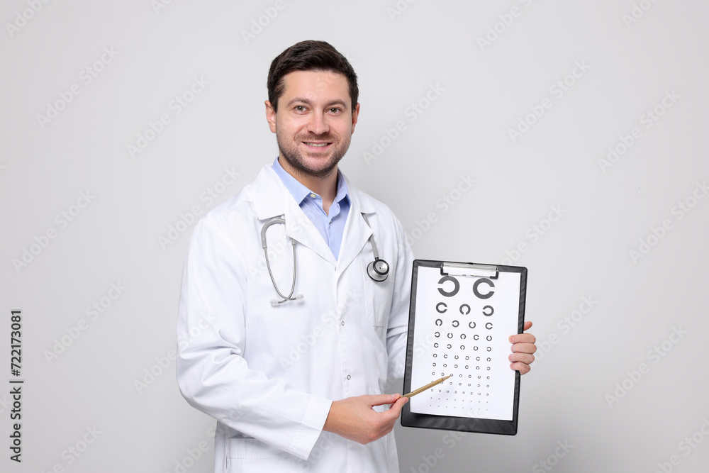 Ophthalmologist pointing at vision test chart on light background Ophthalmologist pointing at vision test chart on light background