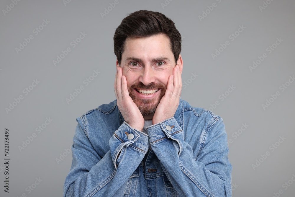 Obraz premium Portrait of happy surprised man on grey background