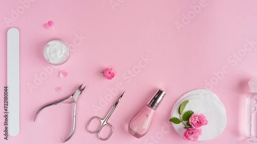 Salon manicure concept photo. Manicure equipment with nail polish and rose petals pink background top view space for text