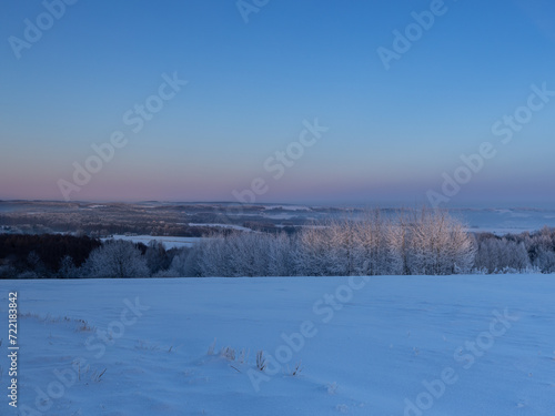 Obraz na płótnie Winter sunset over the tops of frozen trees w salonie