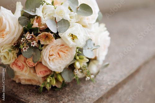 An elegant bouquet with blooming white roses and delicate blue flowers rests on a granite stone. Concept for wedding arrangements  floral designs  or romantic events.