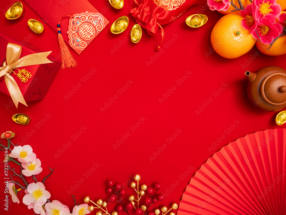 flat lay of lucky item decoration ornament for Chinese Lunar New Year celebration red background with ancient Chinese gold bar, gift box , paper hand fan, Tae Eia envelope (red envelope), orange, plum flat lay of lucky item decoration ornament for Chinese Lunar New Year celebration red background with ancient Chinese gold bar, gift box , paper hand fan, Tae Eia envelope (red envelope), orange, plum