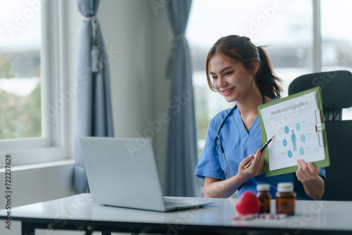 Doctor or nurse consulting with patient online using laptop computer in hospital. photo