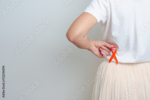 Woman having back abdomen pain with Orange ribbon. Kidney Cancer Awareness March month, disease of Urinary system and Stones, Cancer, Chronic kidney, Urology, Renal and Transplant concept photo