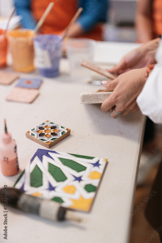 artist at work making clay tile in a tile factory and pottery studio artist at work making clay tile in a tile factory and pottery studio