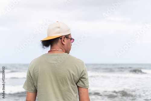 Latin man Contemplating Ocean Waves
