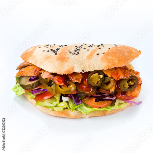 Flatbread with stuffing of fresh vegetable salad with tomatoes, chicken, pork, lettuce, cheese, pickled cucumbers, cabbage and jalapeno pepper on white background.