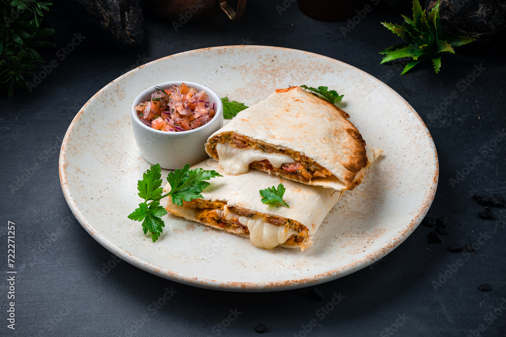 Flatbread with stuffing, sauce, tomatoes, onions, parsley and ham with fresh vegetable salad.