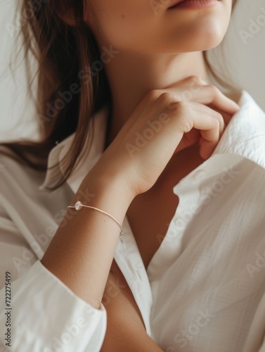 Close-up of a delicate bracelet on a woman's wrist with a white shirt photo