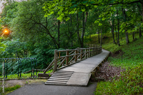 The boardwalks leading through the park at sunrise. Smiltene Old Park, Latvia. Wooden walkway. photo