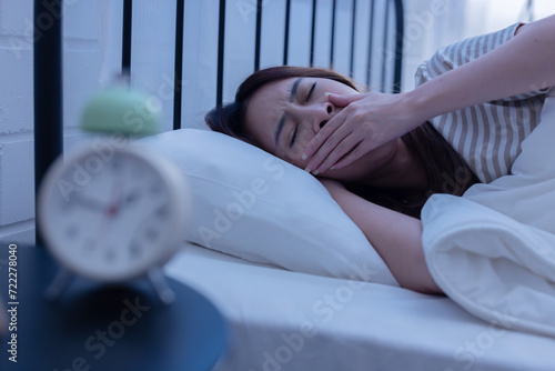 Asian woman suffer from insomnia on her bed at night photo