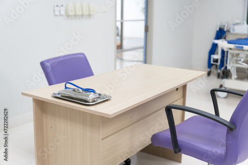 Interior of empty physician office with desk and chairs.Modern and bright doctor office with copy space.Medical tools at doctor working table. © arcyto
