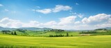 Beautiful natural landscape panorama of green field of cut grass with blue sky with clouds on the horizon. Perfect green lawn on a sunny summer day...