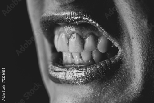 Foto Tense female lips and teeth in the dark, emotion of anger and rage, crib and rag