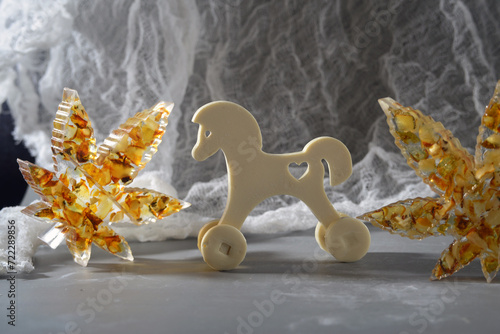 Wooden epoxy resin toy horse on a background of white lace. Copy space.