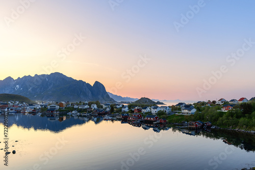 Tranquil summer night at Reine, Lofoten Islands, Norway, with colorful houses reflected in still waters under a soft twilight sky