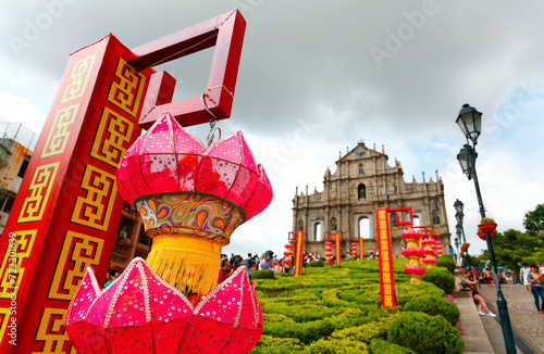 Close up view of colorful traditional Chinese lanterns before the facade of the Ruins of St. Paul's Church in the Historic Center of Macau, China, a contrast and mixture of the West and the East photo