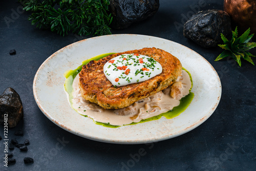 Potato pancakes with mushrooms, onions, sauce, caviar and sour cream.