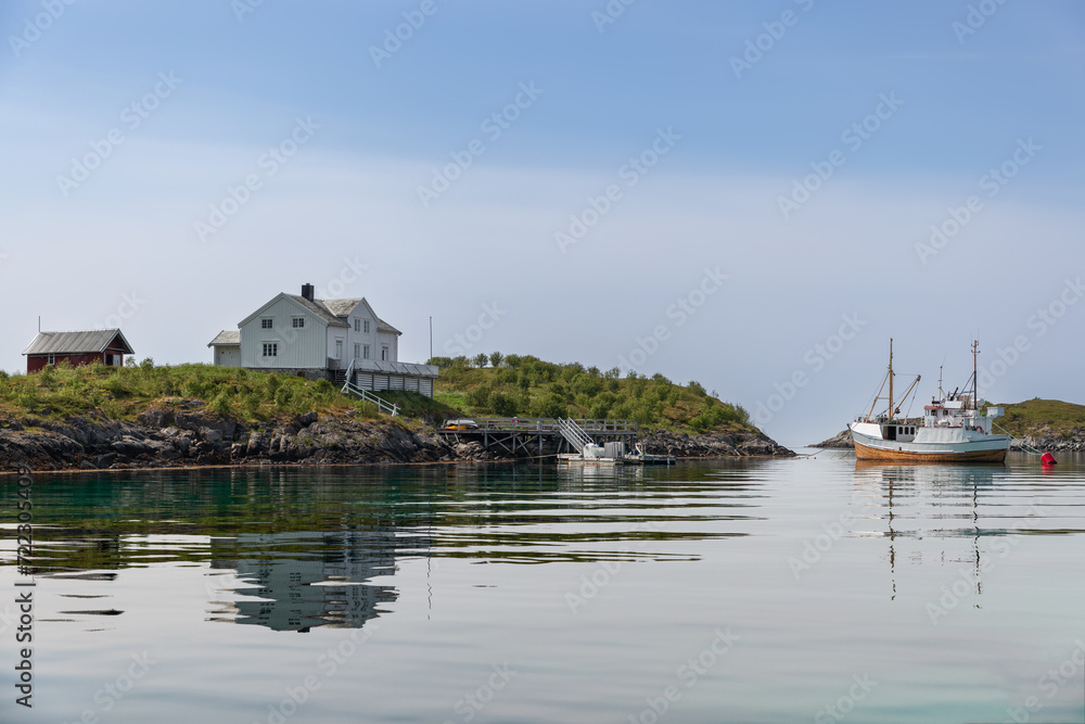 A serene Norwegian landscape, with Rorbu cabins and a docked fishing vessel mirrored on the tranquil waters of Lofoten. Norway A serene Norwegian landscape, with Rorbu cabins and a docked fishing vessel mirrored on the tranquil waters of Lofoten. Norway