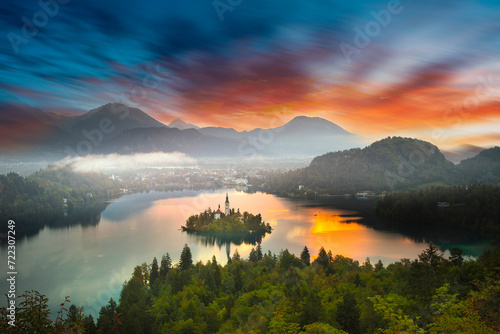 Famous alpine Bled lake  Blejsko jezero  in Slovenia  amazing autumn landscape. Scenic view of the lake  island with church  Bled castle  mountains and blue sky with clouds  outdoor travel background