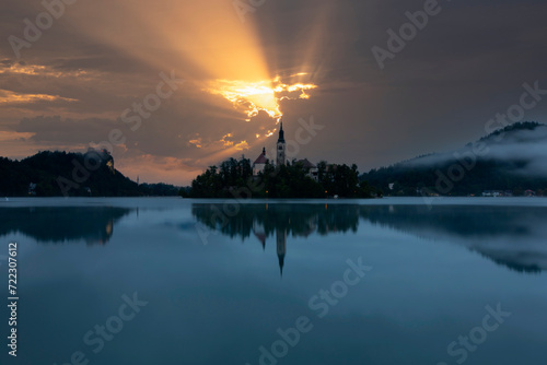 Famous alpine Bled lake (Blejsko jezero) in Slovenia, amazing autumn landscape. Scenic view of the lake, island with church, Bled castle, mountains and blue sky with clouds, outdoor travel background © Samet