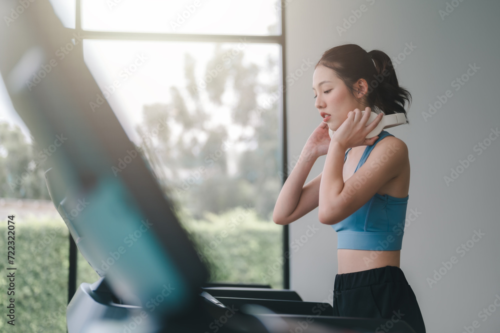 sport, fitness, woman, fit, earphones, exercise, healthy, lifestyle, treadmill, music. side view of young woman running on treadmill and listening to music via headphone during sports training in gym. sport, fitness, woman, fit, earphones, exercise, healthy, lifestyle, treadmill, music. side view of young woman running on treadmill and listening to music via headphone during sports training in gym.