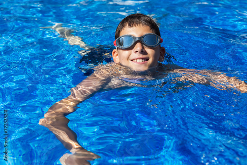 Little boy swimming in the pool. Summer break vacation