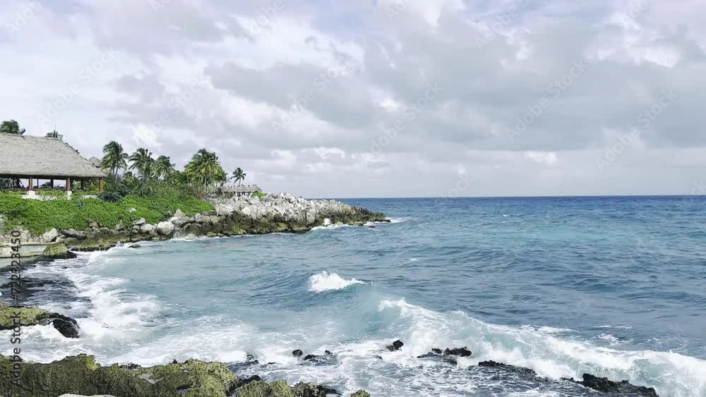 Mar caribe de agua turquesa con olas grandes rompiendo sobre una caleta y rocas en playas de Cancún México Mar caribe de agua turquesa con olas grandes rompiendo sobre una caleta y rocas en playas de Cancún México