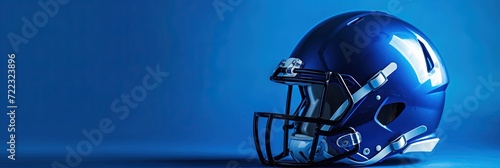Football helmet on solid blue color background with copy space