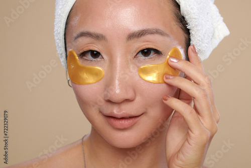 Face of Chinese young woman applying under eye hydrogel patches