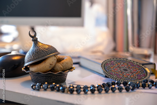 arabic sweets on office desk with quran and rosary photo