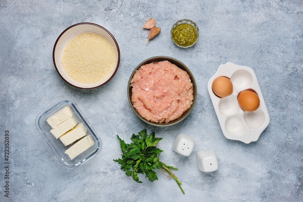 Step-by-step cooking of meatballs stuffed with feta and pesto sauce. Step one, prepared ingredients on a gray concrete background. Step-by-step recipes. Step-by-step cooking of meatballs stuffed with feta and pesto sauce. Step one, prepared ingredients on a gray concrete background. Step-by-step recipes.
