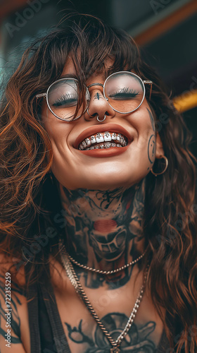 Tattooed woman with silver dental grillz and piercings photo