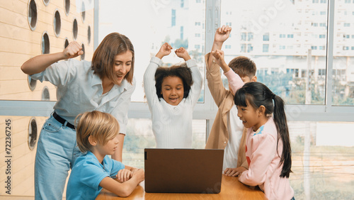 Group of diverse student and teacher celebrate successful project. Happy caucasian instructor looking at engineering code and cheering and encourage learner to improve skill at STEM class. Erudition. © Summit Art Creations