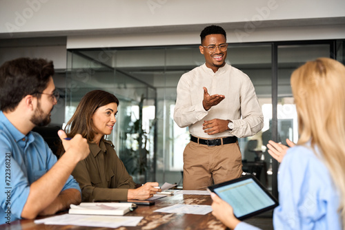 Canvastavla Young happy African American male executive company leader discussing project management planning strategy working with diverse busy colleagues company team at office corporate board group meeting