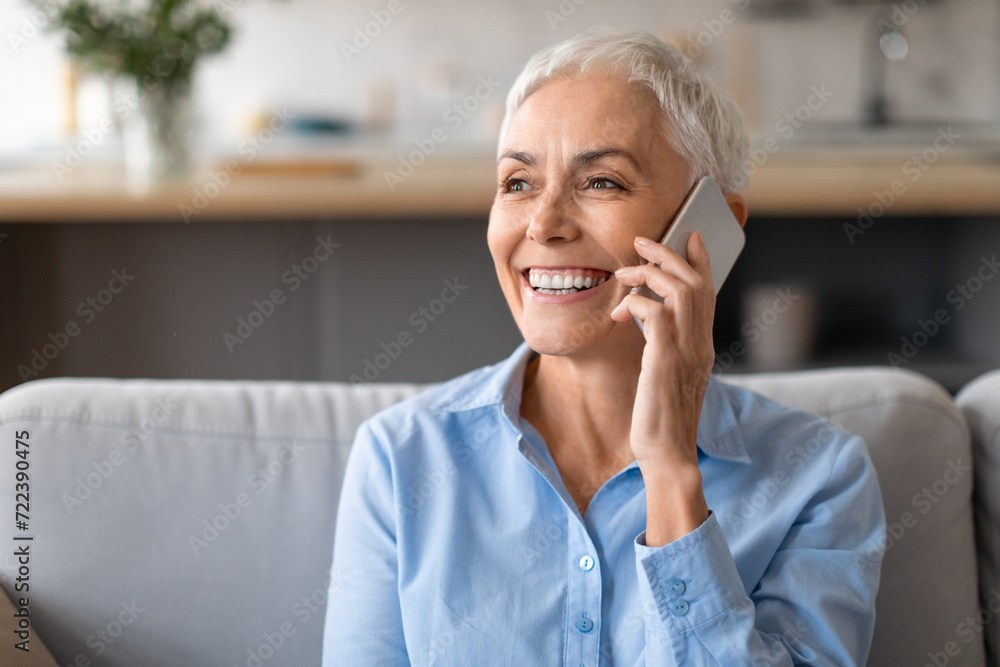 Portrait shot of happy mature lady talking on cellphone indoors Portrait shot of happy mature lady talking on cellphone indoors
