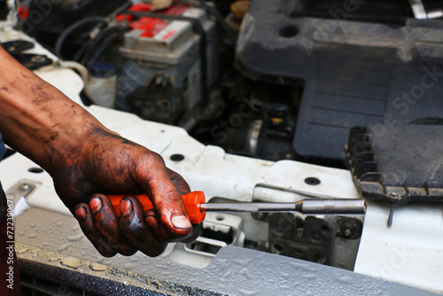 Black greasy hands of man working in car repair
