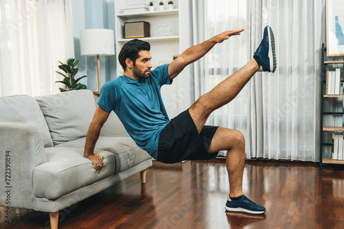 Fotografie, Obraz Athletic body and active sporty man using furniture for effective targeting muscle gain exercise at gaiety home exercise as concept of healthy fit body home workout lifestyle