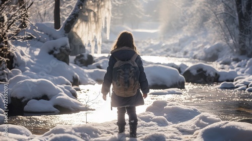 A little girl in a stream of water in the spring when the snow melts © Larisa