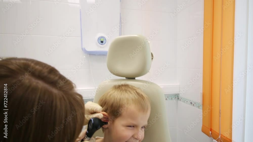 ENT specialist is inspecting little boys ears by auriscope. ENT specialist is inspecting little boys ears by auriscope.