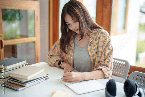 Self learning concept. Young woman student university Researching Book In Library. University Student